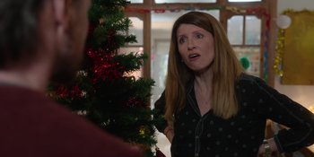 Movie still from “Together” (2021), directed by Justin Martin – A woman standing in front of a christmas tree; Medium shot, Over the shoulder angle