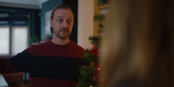 Movie still from “Together” (2021), directed by Justin Martin – A man standing in front of a christmas tree looking in the mirror; Close Up shot, Over the shoulder angle
