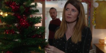 Movie still from “Together” (2021), directed by Justin Martin – A woman standing in front of a christmas tree; Medium shot, Over the shoulder angle