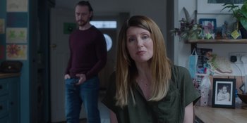 Movie still from “Together” (2021), directed by Justin Martin – A man and a woman standing next to each other in a room; Medium shot, Over the shoulder angle