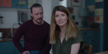 Movie still from “Together” (2021), directed by Justin Martin – A woman and a man sitting in front of each other in a living room; Medium shot, Over the shoulder angle