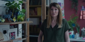 Movie still from “Together” (2021), directed by Justin Martin – A woman standing in front of a bookshelf in a living room; Close Up shot, Over the shoulder angle