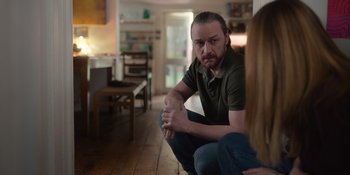 Movie still from “Together” (2021), directed by Justin Martin – A man sitting on the ground in front of a woman; Medium shot, Over the shoulder angle