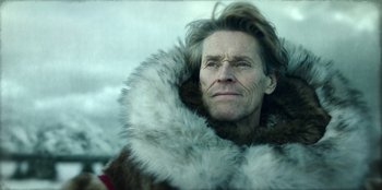 Movie still from “Togo” (2019), directed by Ericson Core – An older man wearing a fur coat with a fur collar; Close Up shot, Low angle