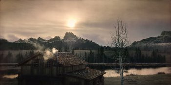 Movie still from “Togo” (2019), directed by Ericson Core – A house sitting next to a body of water; Extreme Wide shot, High angle