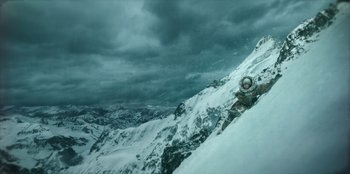 Movie still from “Togo” (2019), directed by Ericson Core – A person on a snow board on a snowy mountain; Wide shot, Low angle