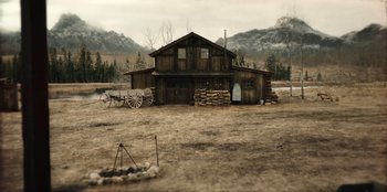 Movie still from “Togo” (2019), directed by Ericson Core – An old barn with a wagon in front of it; Extreme Wide shot, High angle