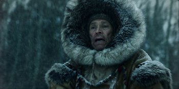 Movie still from “Togo” (2019), directed by Ericson Core – An old man in a fur coat and a fur hat; Close Up shot, Low angle