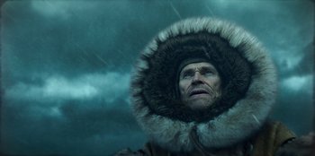 Movie still from “Togo” (2019), directed by Ericson Core – A man in a fur coat and a fur hat in the rain; Close Up shot, Low angle