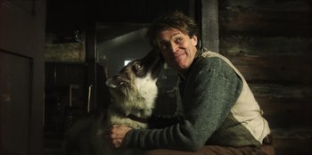 Movie still from “Togo” (2019), directed by Ericson Core – A man holding a cat in his arms; Close Up shot, Low angle