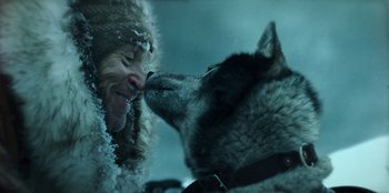 Movie still from “Togo” (2019), directed by Ericson Core – A man and a dog are kissing each other in the snow; Close Up shot, Low angle