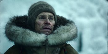 Movie still from “Togo” (2019), directed by Ericson Core – An older man wearing a fur coat and a hat; Close Up shot, Low angle