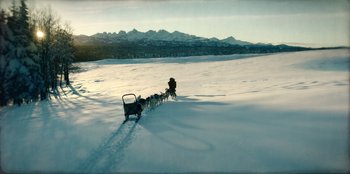 Movie still from “Togo” (2019), directed by Ericson Core – A dog pulling a sled down a snow covered slope; Extreme Wide shot, High angle