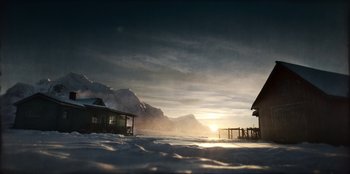 Movie still from “Togo” (2019), directed by Ericson Core – The sun is setting over a snowy mountain; Extreme Wide shot, High angle