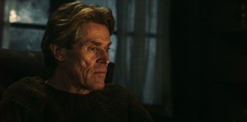 Movie still from “Togo” (2019), directed by Ericson Core – An older man is sitting down while talking on a cell phone; Close Up shot, Low angle