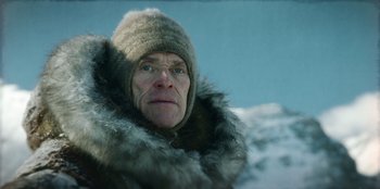 Movie still from “Togo” (2019), directed by Ericson Core – An older man wearing a hat and a fur coat; Close Up shot, Low angle