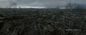 Movie still from “Without Remorse” (2021), directed by Stefano Sollima – An aerial view of a destroyed city with dark skies above it; Extreme Wide shot, High angle