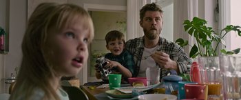 Movie still from “Without Remorse” (2021), directed by Stefano Sollima – A man and two boys sitting at a dinner table; Medium shot, Over the shoulder angle