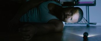 Movie still from “Without Remorse” (2021), directed by Stefano Sollima – A man laying on the ground in the dark; Close Up shot, Overhead angle