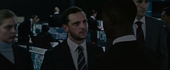 Movie still from “Without Remorse” (2021), directed by Stefano Sollima – A man wearing a suit and tie talking to another man in a suit; Close Up shot, Over the shoulder angle