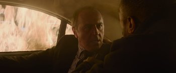 Movie still from “Without Remorse” (2021), directed by Stefano Sollima – An older man sitting in the back seat of a car; Close Up shot, Over the shoulder angle