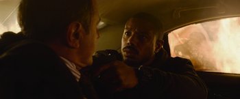 Movie still from “Without Remorse” (2021), directed by Stefano Sollima – A man in a car looking at another man in a suit; Close Up shot, Over the shoulder angle