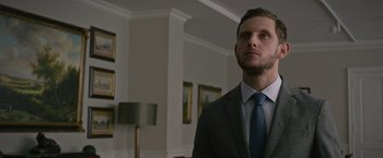 Movie still from “Without Remorse” (2021), directed by Stefano Sollima – A man wearing a suit and tie in a room; Close Up shot, Low angle