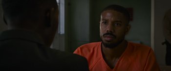 Movie still from “Without Remorse” (2021), directed by Stefano Sollima – A man in an orange shirt is talking to someone; Close Up shot, Over the shoulder angle