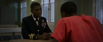 Movie still from “Without Remorse” (2021), directed by Stefano Sollima – A man in a uniform talking to another man; Medium shot, Over the shoulder angle