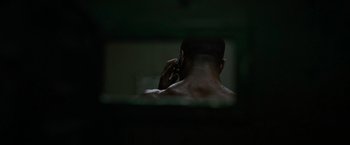 Movie still from “Without Remorse” (2021), directed by Stefano Sollima – A shirtless man talking on a cell phone in the dark; Extreme Close Up shot, High angle