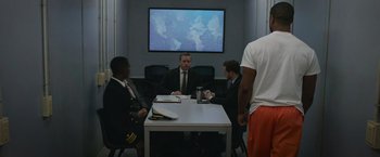 Movie still from “Without Remorse” (2021), directed by Stefano Sollima – A group of men sitting at a table in front of a projection screen; Wide shot, Over the shoulder angle