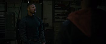 Movie still from “Without Remorse” (2021), directed by Stefano Sollima – A man standing in a room next to another man; Medium shot, Over the shoulder angle