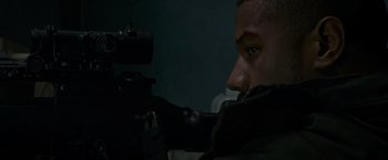 Movie still from “Without Remorse” (2021), directed by Stefano Sollima – A man is holding a gun and looking at the camera; Close Up shot, Over the shoulder angle