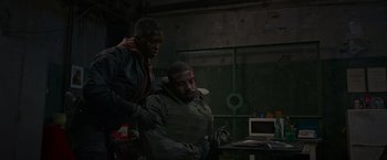 Movie still from “Without Remorse” (2021), directed by Stefano Sollima – Two men are sitting in a dark room; Medium shot, Over the shoulder angle