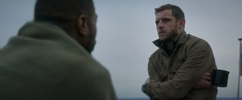 Movie still from “Without Remorse” (2021), directed by Stefano Sollima – Two men standing next to each other on a beach; Close Up shot, Low angle