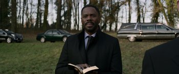 Movie still from “Without Remorse” (2021), directed by Stefano Sollima – A man in a black jacket holding an open book; Close Up shot, Low angle