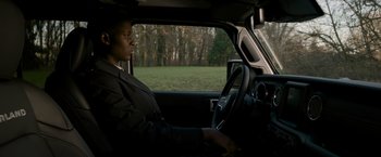 Movie still from “Without Remorse” (2021), directed by Stefano Sollima – A person sitting in a car in the driver's seat of a vehicle; Medium shot, Over the shoulder angle