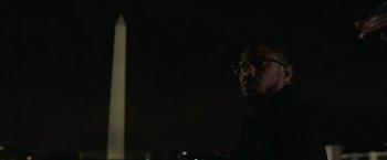 Movie still from “Without Remorse” (2021), directed by Stefano Sollima – A man with glasses standing in front of the washington monument at night; Close Up shot, Low angle
