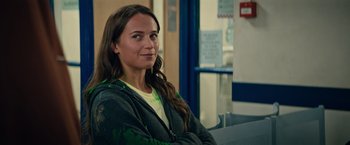 Movie still from “Tomb Raider” (2018), directed by Roar Uthaug – A woman sitting on a bench in front of a window; Close Up shot, Over the shoulder angle