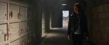 Movie still from “Tomb Raider” (2018), directed by Roar Uthaug – A woman in a leather jacket walking down a hallway; Medium shot, Low angle