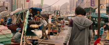 Movie still from “Tomb Raider” (2018), directed by Roar Uthaug – A group of people standing on top of a wooden dock; Wide shot, Over the shoulder angle