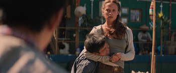 Movie still from “Tomb Raider” (2018), directed by Roar Uthaug – A man and a woman are hugging in a street; Medium shot, Over the shoulder angle