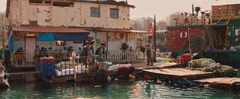 Movie still from “Tomb Raider” (2018), directed by Roar Uthaug – A group of people standing on a dock next to a body of water; Wide shot, High angle