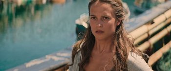 Movie still from “Tomb Raider” (2018), directed by Roar Uthaug – A beautiful young woman with long brown hair; Close Up shot, Over the shoulder angle