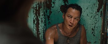 Movie still from “Tomb Raider” (2018), directed by Roar Uthaug – A person wearing a tank top near a wall; Close Up shot, High angle