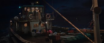 Movie still from “Tomb Raider” (2018), directed by Roar Uthaug – People are sitting on the deck of a boat at night; Wide shot, High angle