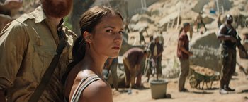 Movie still from “Tomb Raider” (2018), directed by Roar Uthaug – A woman standing in front of a group of people; Close Up shot, Over the shoulder angle