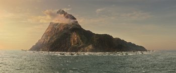 Movie still from “Tomb Raider” (2018), directed by Roar Uthaug – A large body of water near a large mountain; Extreme Wide shot, High angle