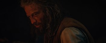 Movie still from “Tomb Raider” (2018), directed by Roar Uthaug – A person with long hair and a beard; Close Up shot, Over the shoulder angle