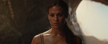 Movie still from “Tomb Raider” (2018), directed by Roar Uthaug – A person wearing a tank top; Close Up shot, Over the shoulder angle